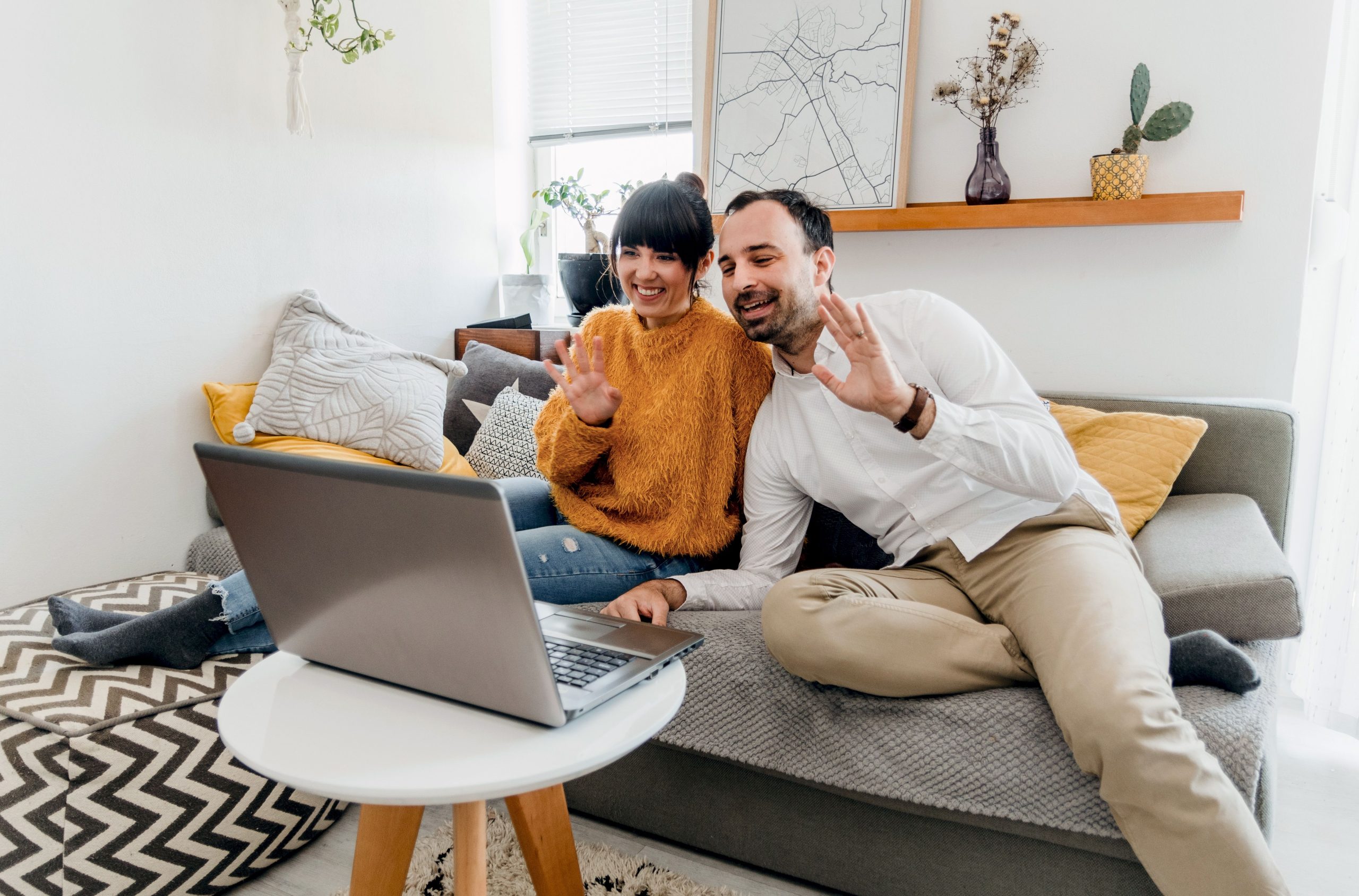 Couple sharing a video call together on a laptop in their living room
