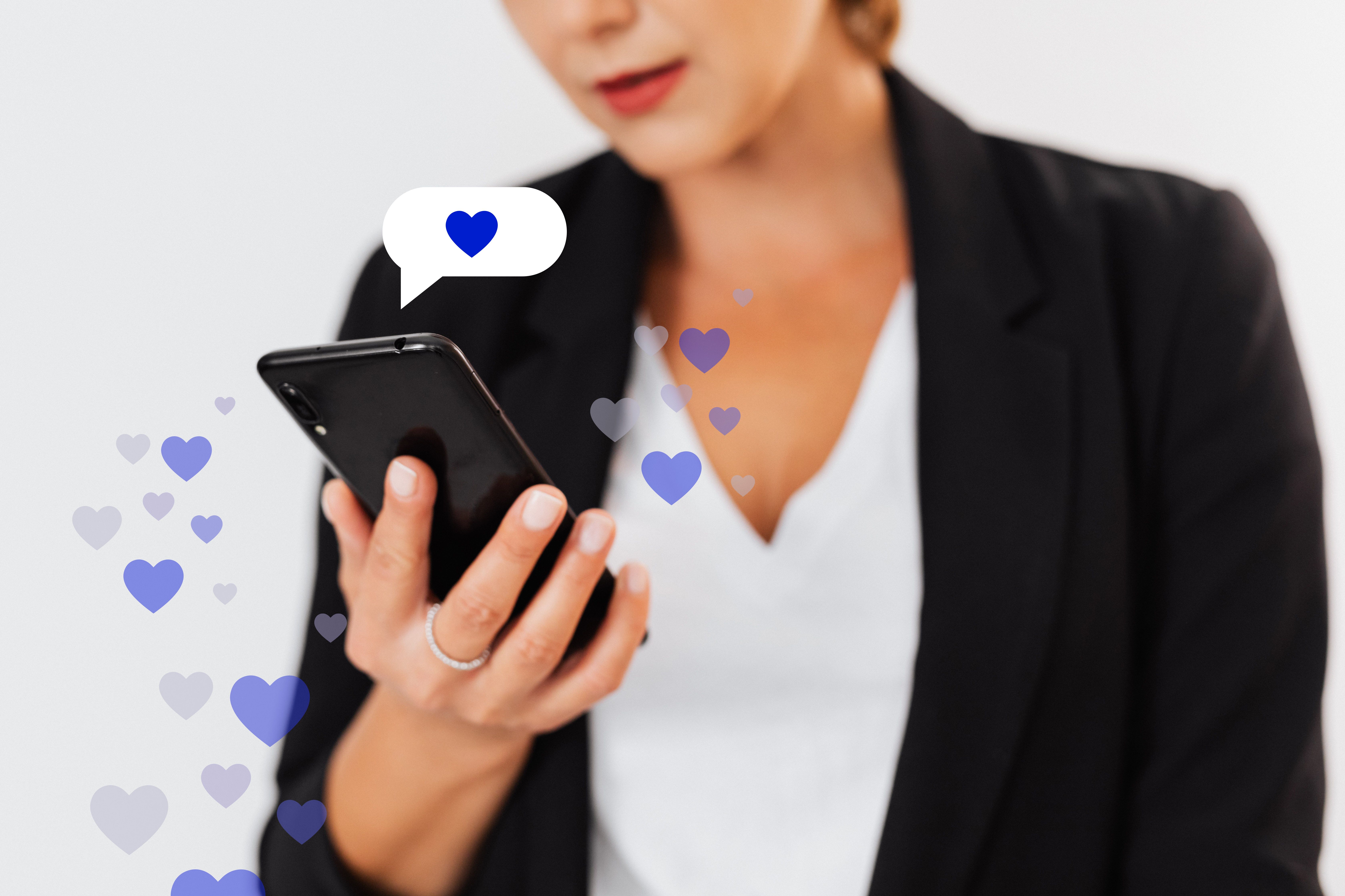 Woman holding a smartphone with floating heart icons symbolizing digital affection