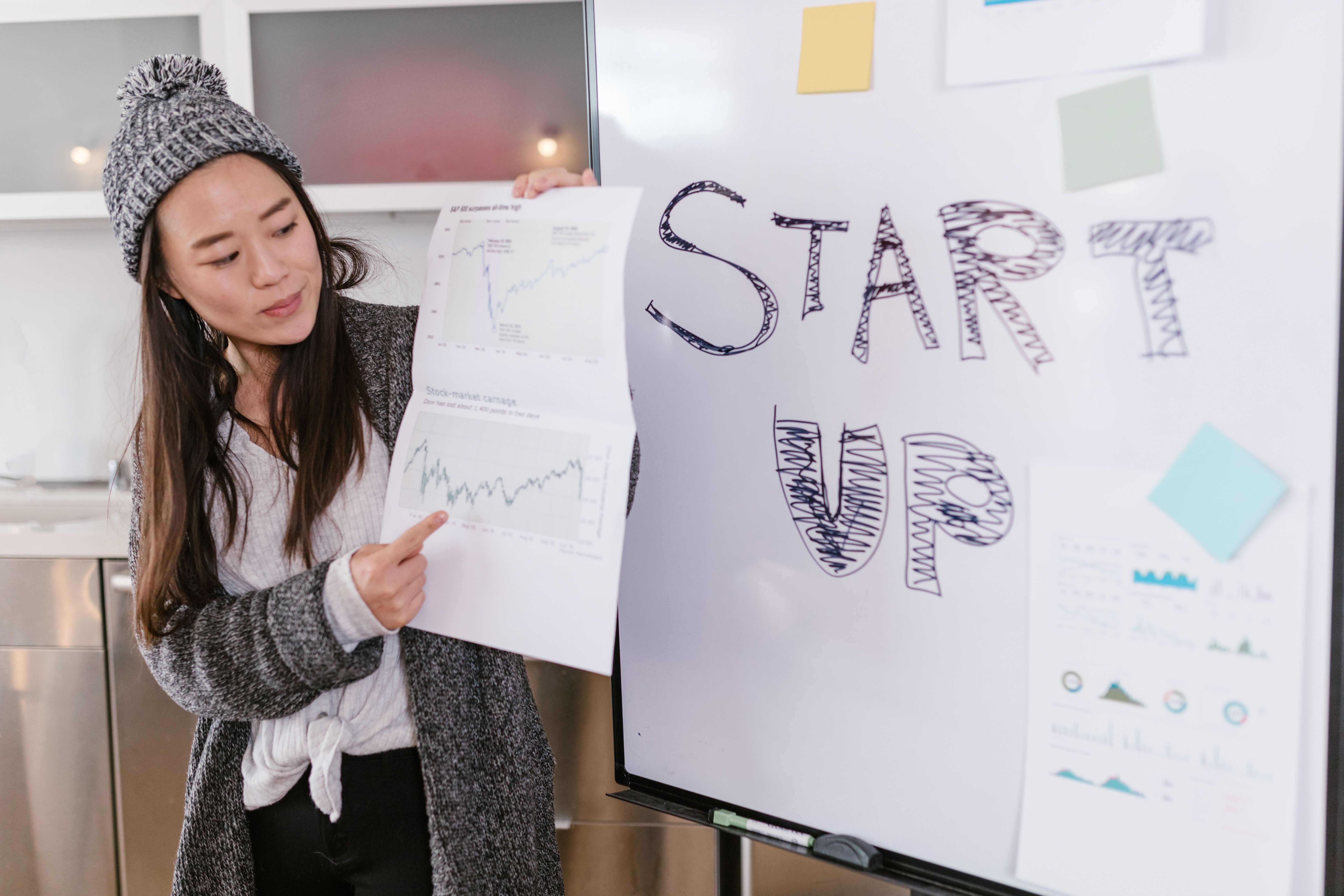 Woman presenting business growth charts during a startup pitch indoors